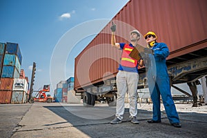 Foreman and dock worker staff working checking at Container cargo harbor holding clipboard. Business Logistics import export