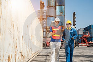 Foreman and dock worker staff working checking at Container cargo harbor holding clipboard. Business Logistics import export