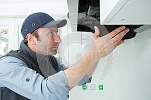 Foreman fixing exhaust hood in kitchen