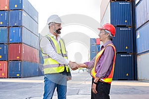 Foreman handshake engineer control loading Containers box from Cargo freight ship for import export. Freight containers in sea