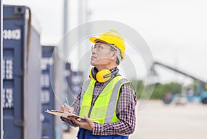 Foreman in hardhat and safety vest control loading containers box from cargo, Engineer with clipboard checklist, Industrial worker