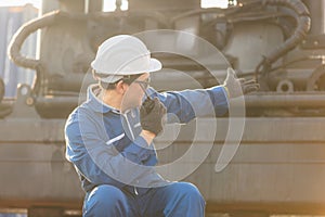 Foreman in hardhat and safety vest talks on two-way radio control loading containers box from cargo