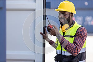 Foreman holding walkie- talkie for control working at Container cargo site. Handheld walkie talkie for outdoor