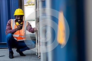 Foreman holding walkie- talkie for control working at Container cargo site. Handheld walkie talkie for outdoor