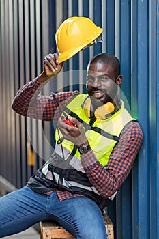 Foreman holding walkie- talkie for control working at Container cargo site. Handheld walkie talkie for outdoor