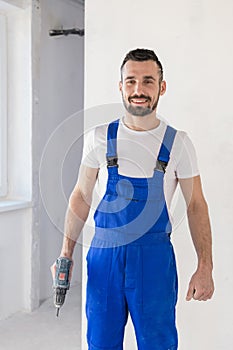 The foreman holds a drill in his hand