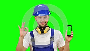 Foreman holds a phone in his hands and shows a thumbs up. Green screen. Mock up