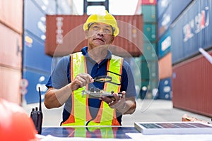 Foreman man working checking at Container cargo harbor to loading containers. Professional foreman work at Container cargo site ch