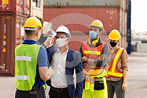 Foreman using an infrared thermometer measuring temperature to check the worker