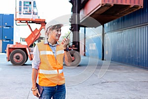 Foreman using radio walkie talkie control loading containers box in cargo for import export, Professional engineer work checking