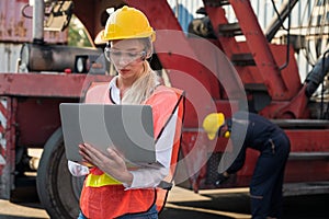 Foreman woman and worker man operate checking the forklift container cargo harbor holding laptop computer