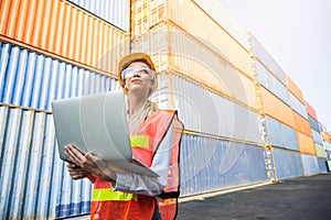 Foreman woman worker working checking at Container cargo harbor holding laptop computer to loading containers. Dock female staff