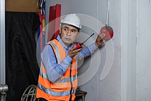 Foreman or worker pushing fire alarm on the wall. A fire! or Emergency case at the factory building. Emergency of Fire alarm or al