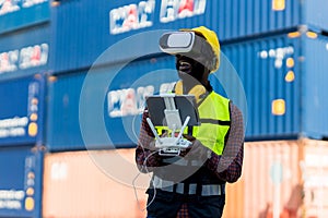Foreman or worker use remote controller piloting drone at containers port for checking container. Foreman use remote control Drone