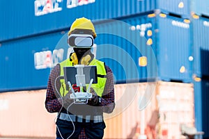 Foreman or worker use remote controller piloting drone at containers port for checking container. Foreman use remote control Drone