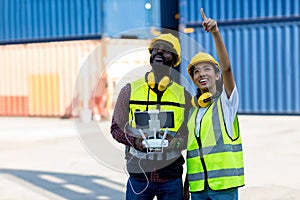 Foreman or worker use remote controller piloting drone at containers port for checking container. Foreman use remote control Drone