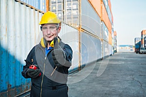 Foreman worker working checking at Container cargo harbor holding radio walkie-talkie to loading containers. Dock male staff