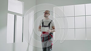 Foreman in workwear with clipboard inspects repaired room