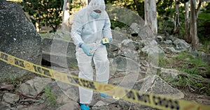 Forensic, evidence marker and csi for investigation at crime scene with police tape or hazmat for safety in forest