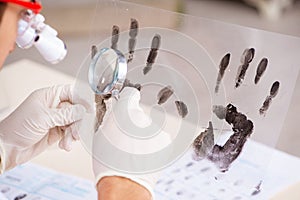 The forensic expert studying fingerprints in the lab