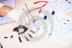 The forensic expert studying fingerprints in the lab