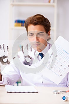 The forensic expert studying fingerprints in the lab