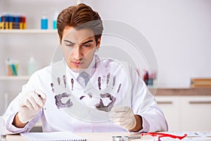 The forensic expert studying fingerprints in the lab