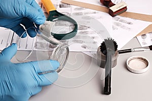 Forensic fingerprint analysis, criminalist collects latent fingerprints using fingerprint powder on evidence