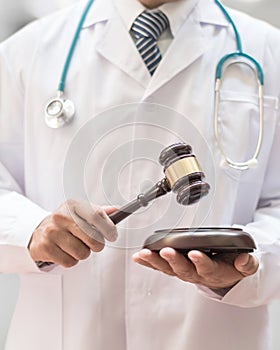 Forensic medicine legal investigation or medical practice - malpractice justice concept with judge gavel in doctor`s hands