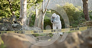 Forensic, photographer and evidence at crime scene for investigation in forest with police tape and safety ppe..Csi