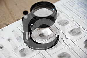 forensic scientist examines fingerprints with a magnifying glass in a laboratory.