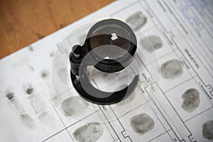 A forensic scientist with a magnifying glass studies fingerprints in a laboratory