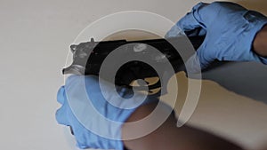 Forensic scientist putting down a gun with prints