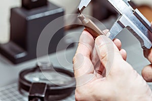 A forensic service officer measures the cartridge case from a firearm with a caliper and conducts a ballistic examination. Close-u