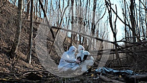 Forensic specialist working in the forest. Police criminalists collecting evidence and making criminal investigation