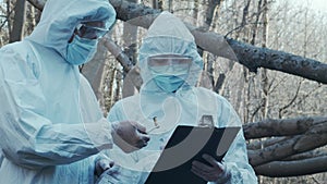 Forensic specialist working in the forest. Police criminalists collecting evidence and making criminal investigation