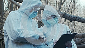 Forensic specialist working in the forest. Police criminalists collecting evidence and making criminal investigation