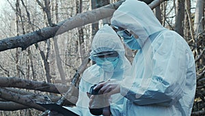 Forensic specialist working in the forest. Police criminalists collecting evidence and making criminal investigation