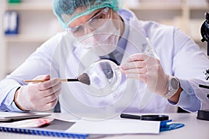 The forensics investigator working in lab on crime evidence photo