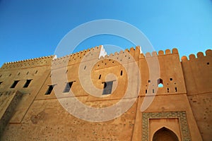 Foreshortening of the external walls of the fort under an intense blue sky, Oman