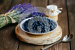 Forest blueberries on a wood table. Fragrant Lavender and Honey with Flowers wood background