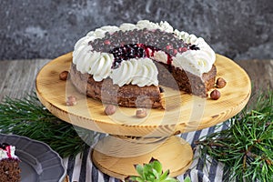 forest chocolate hazelnut cake with wild strawberries, blueberries, raspberries and blackberries garnished with whipped cream