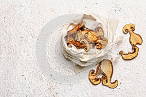 Forest dried edible mushrooms in a linen sack