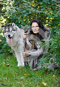 Forest dweller woman with a large dog Alaskan Malamute