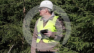 Forest engineer with tablet PC in backwoods