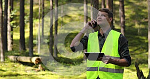 Forest evaluation and management - forestry engineer working with digital tablet in the woods