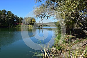 Forest lake in the autumn afternoon. Calm water with reflection of trees