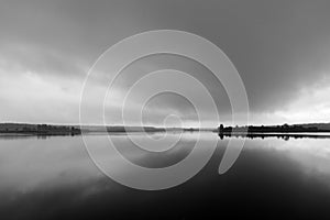 Forest lake in foggy rainy weather. Black and white