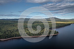 Forest and lakeshore at Lake Siljan from above with blue sky in Dalarna, Sweden