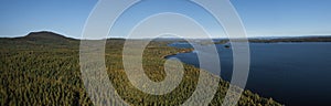 Forest and lakeshore at Lake Siljan from above with blue sky in Dalarna, Sweden